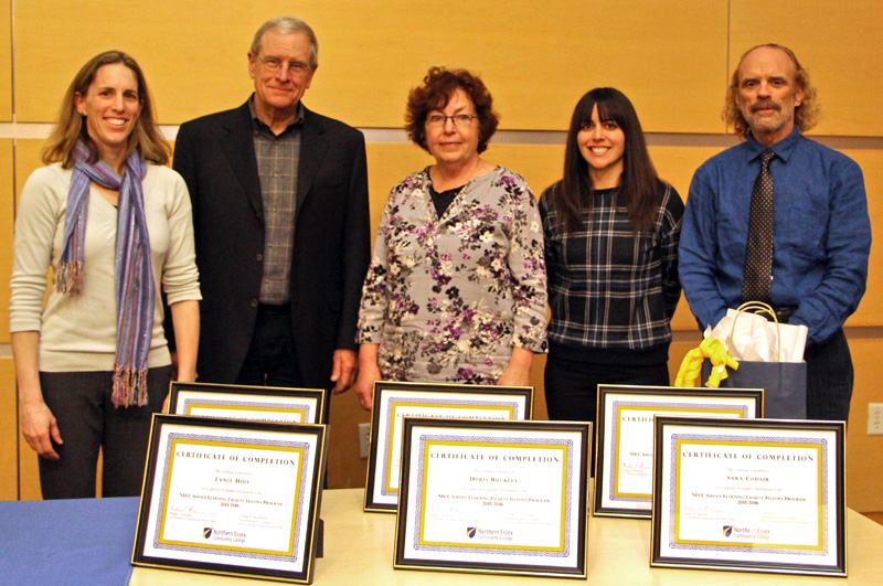 Five Service Learning Faculty Fellows with 6 framed certificates of completion on the table in front of them.